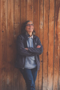 Photo of a woman, Elizabeth Templeman, smiling and leaning against a wall