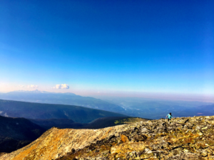 Panoramic landscape of mountain tops from the summit of a mountain, with a very blue sky